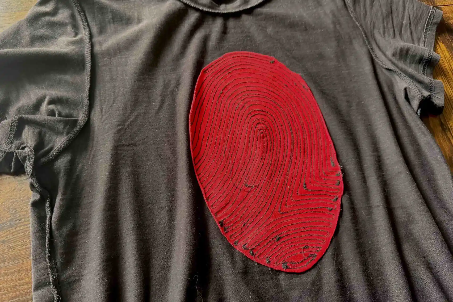 Motivo Fingerprint de Migula Studio, vista del reverso — liberación cortada a mano, hilo crudo y capa interior de piel sintética, Método Monolit